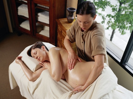 Mulher grávida deitada sendo massageada - GettyImages