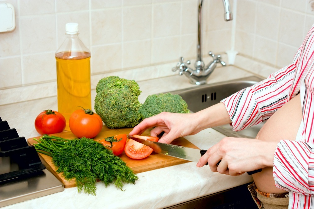 Alimentos sendo preparados por mulher gestante - foto: dmitrieva/ShutterStock.com