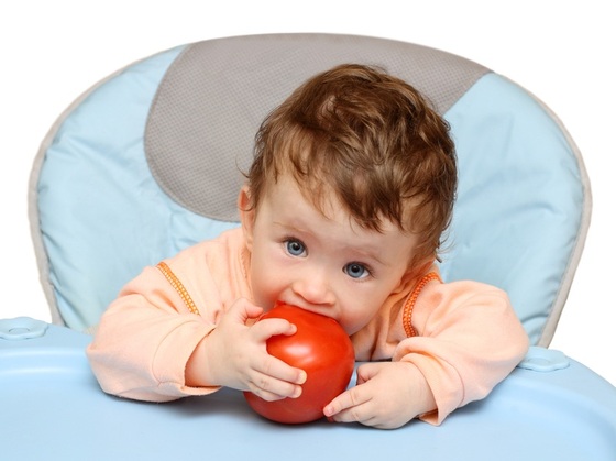 Criança mordendo um tomate - Foto: Kokhanchikov/ShutterStock