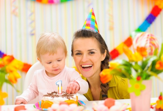 Mamãe ao lado de seu bebê com seu bolo de aniversário de 1 ano - Foto: Alliance/Shutterstock.com