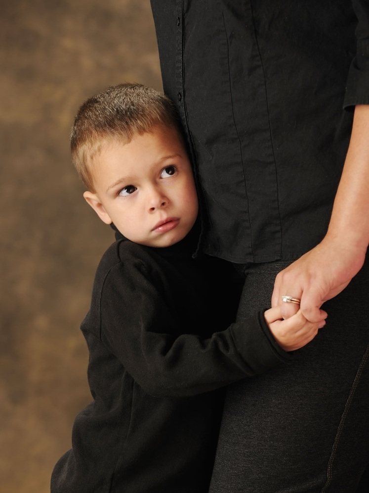 Criança tímida agarrada à mãe - foto: glenda/ShutterStock.com