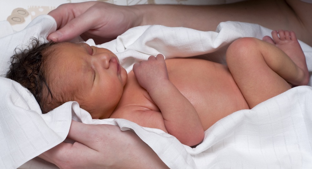 Bebê recém-nascido deitado sobre um toalha - foto: Richard Melichar/ShutterStock.com
