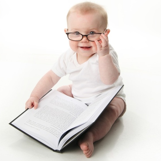 Bebê usando óculos e lendo um livro - blessings / ShutterStock