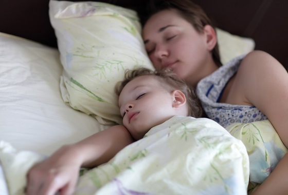 Criança dormindo com a mamãe na mesma cama - Foto: Chubykin Arkady/Shutterstock.com