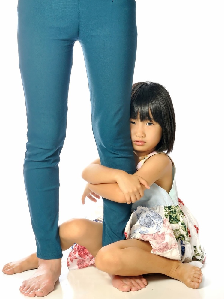 Criança segurando a perna da mãe - foto: varandah/ShutterStock.com