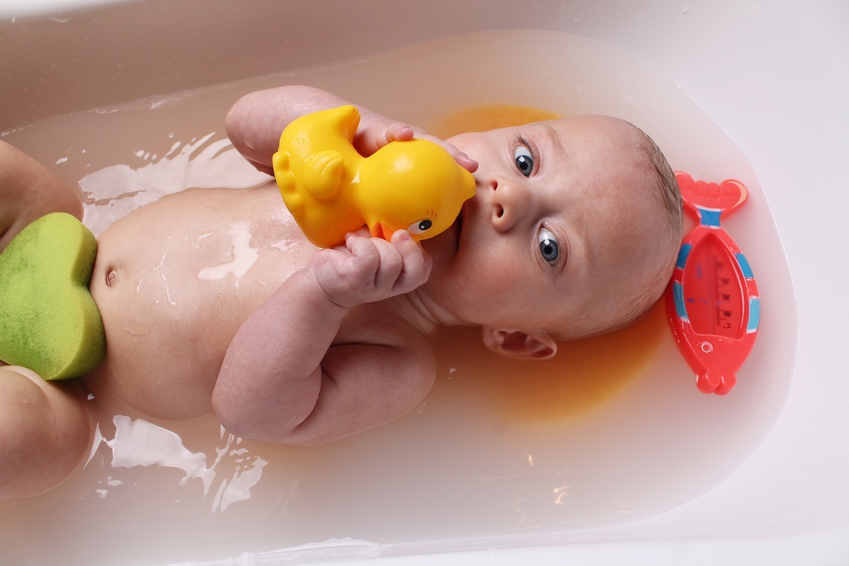 Bebê na banheira brincando com um patinho de borracha - foto: monika3steps/ShutterStock.com