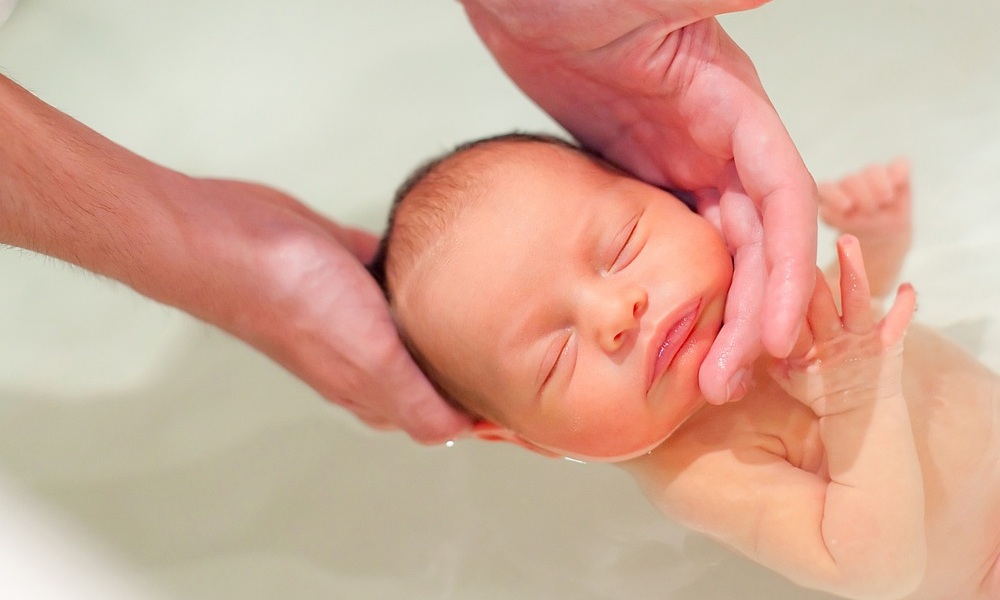 Banho de imersão no bebê. Cabeça fica fora da água - foto: Alina Reynbakh/ShutterStock.com