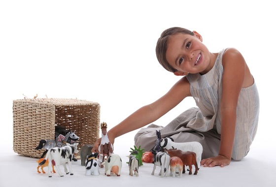 Criança brincando com sua coleção de animais de brinquedo - Foto: auremar/Shutterstock.com