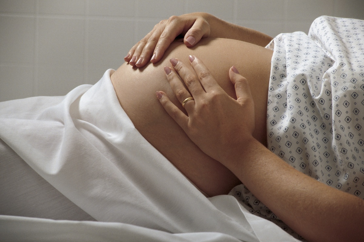 Mulher grávida deitada na sala de parto - ThinkStock