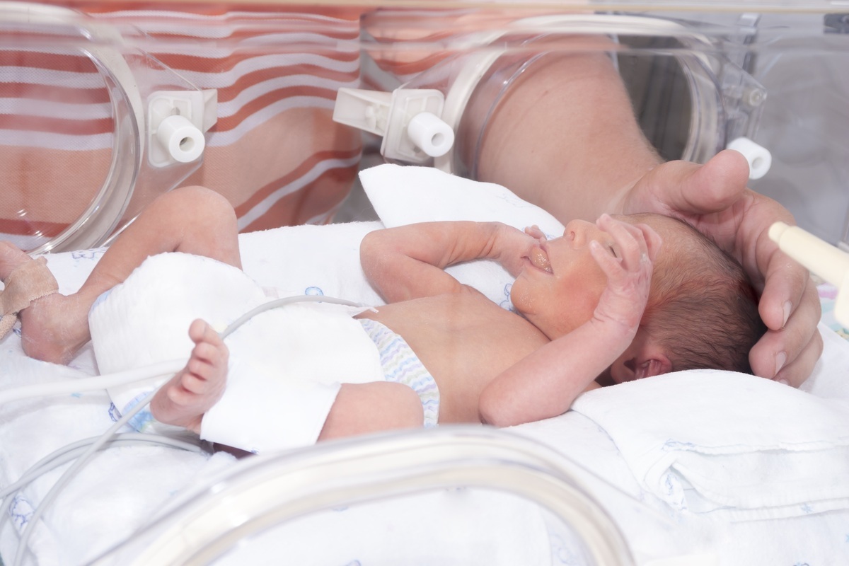 Bebê na incubadora sendo acariciado por sua mãe - foto: herjua/ShutterStock.com