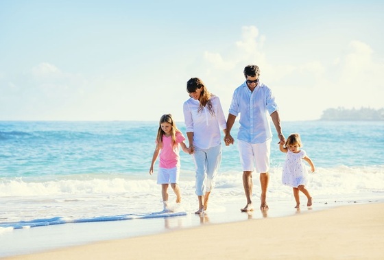 Família passeando à beira da praia