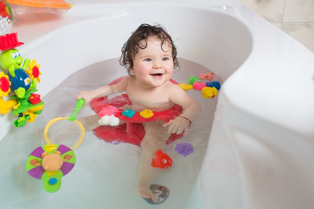 Bebê brincando no banho com brinquedos na banheira - foto: Bolyuk Rostyslav/ShutterStock.com