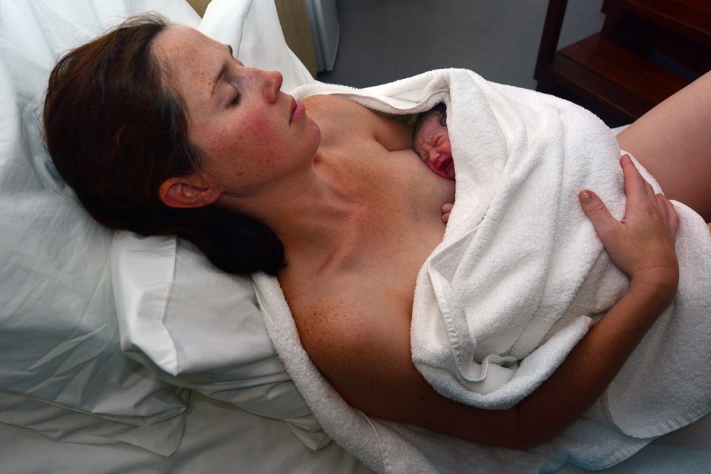 Mãe descansando após o parto com seu bebê no colo - foto: ChameleonsEye/ShutterStock.com
