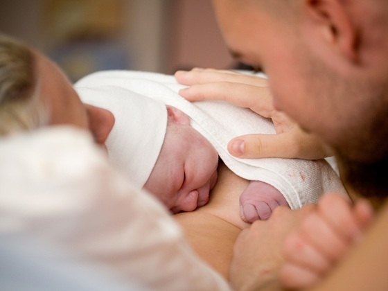 Bebê recém-nascido no colo da mãe e acariciado pelo pai - Foto: Kati Molin / ShutterStock
