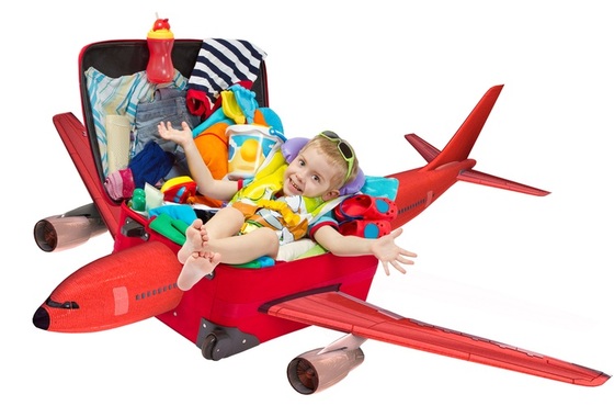 Criança dentro da mala em formato de avião - ShutterStock