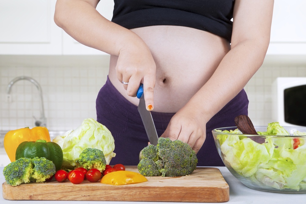 Mulher grávida preparando alimentos - Foto: Creativa Images/ShutterStock.com