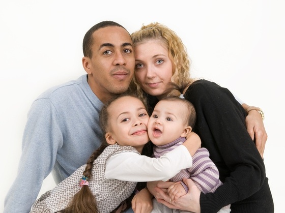 Pai, mãe e filhos abraçados - Foto: Artbox / ShutterStock