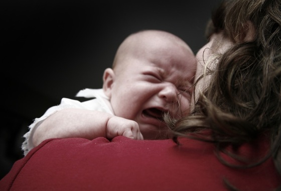 Bebê chorando no colo da mãe - Foto: Johanna Goodyear/Shutterstock.com