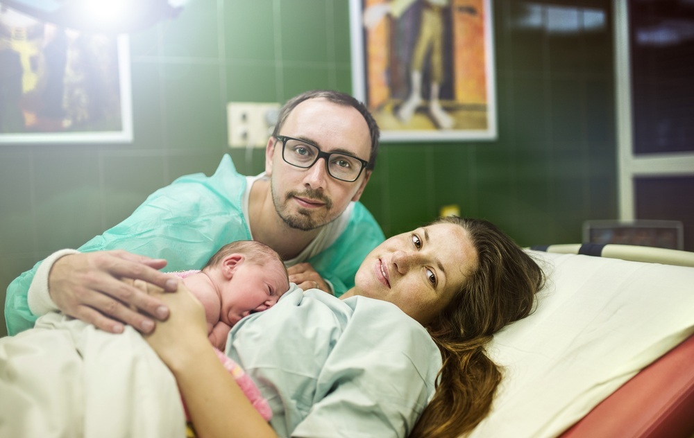 Pai ao lado da esposa e seu bebê recém-nascido - foto: Halfpoint/ShutterStock.com