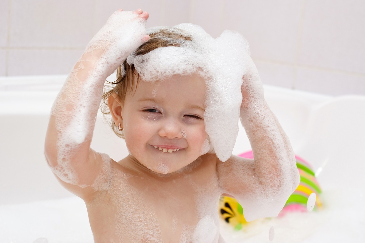 Bebê tomando banho e ensaboando a cabeça - foto: Vitalinka/ShutterStock.com