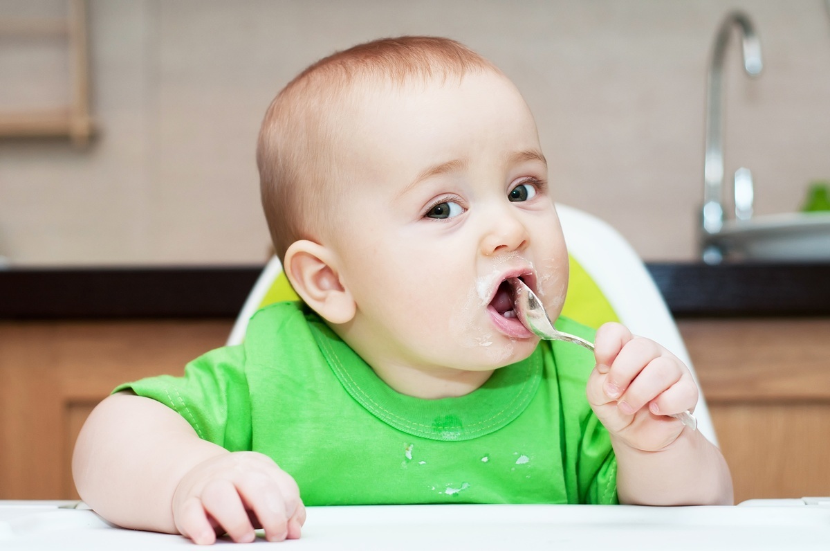 Bebê com uma colher na boca - foto: yellowdays/ShutterStock.com