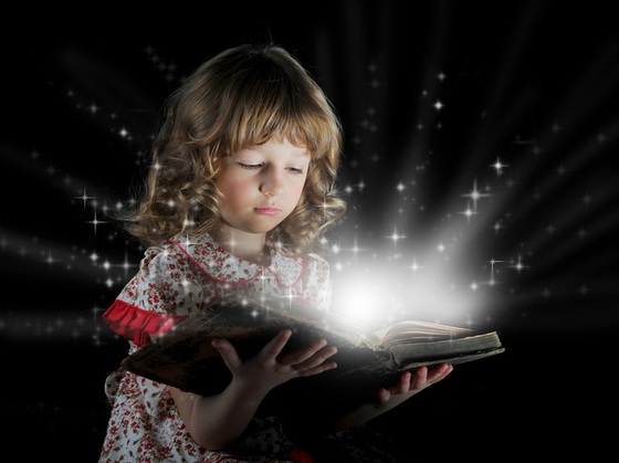 Menina lendo um livro de onde saem estrelas iluminando o ambiente com magia - Valeriy Lebedev / ShutterStock
