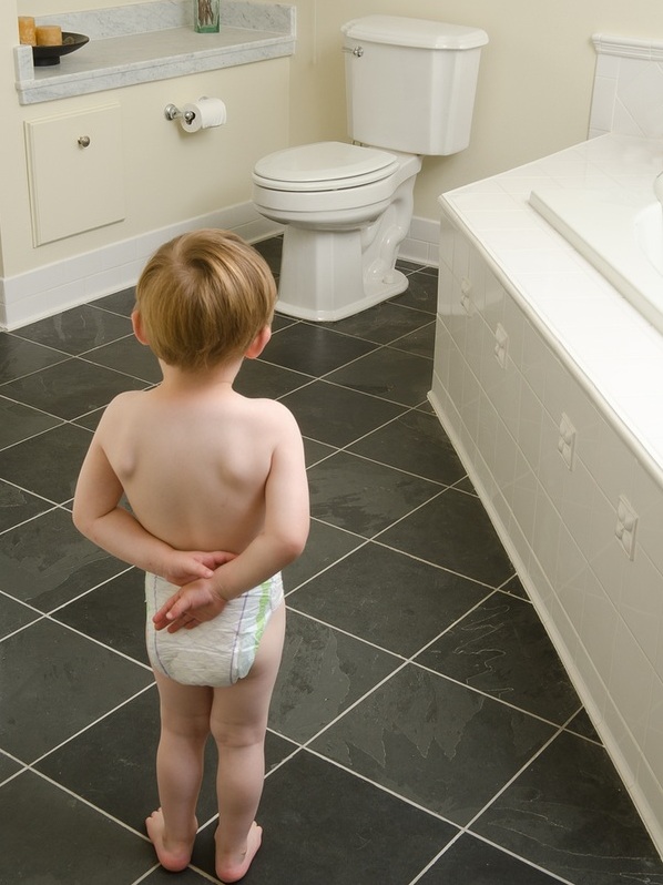 Criança usando fraldas olhando para o vaso sanitário - Foto: jamiehooper/ShutterStock