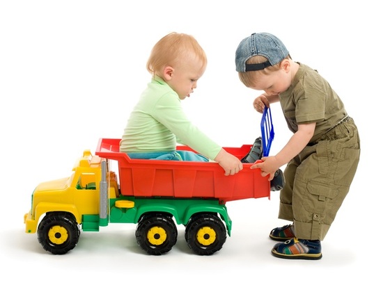 Crianças brincando com um caminhão de brinquedo - Foto: Igor Stepovik/Shutterstock.com